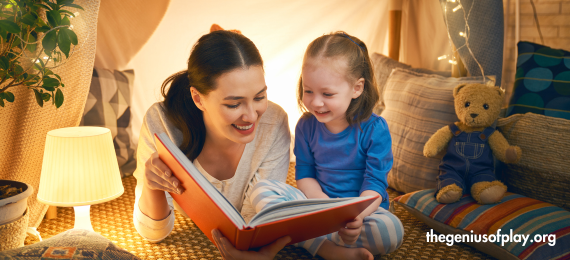 young mother and daughter reading a book together in a bedroom with a teddy bear 